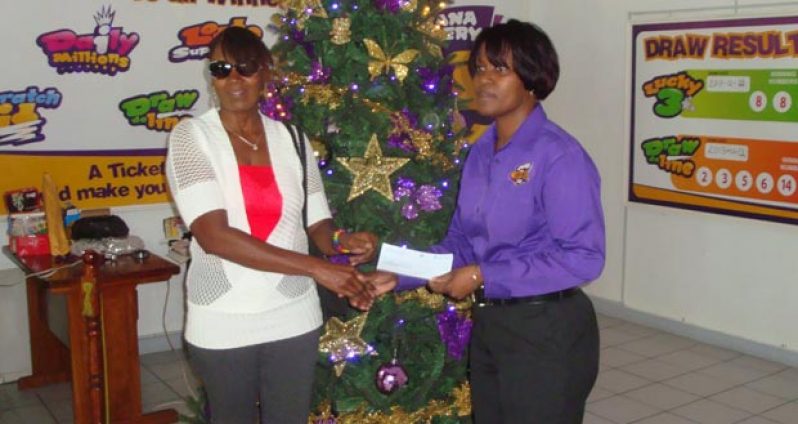 Guyana Lottery Company General Manager Ms. Tracy Lewis (right) yesterday presented a winner’s cheque of $22M to Ms. Sheron Stephens, a housewife from West Coast Demerara, who was blissfully unaware that she was a multimillionaire, until her sister informed her about an unclaimed ticket, for which the 90 days validity period was about to expire.