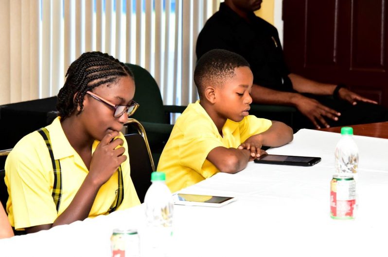 - Two of the students who attended the launch of the N.G.S.A. Practice Exams App busy themselves with its features