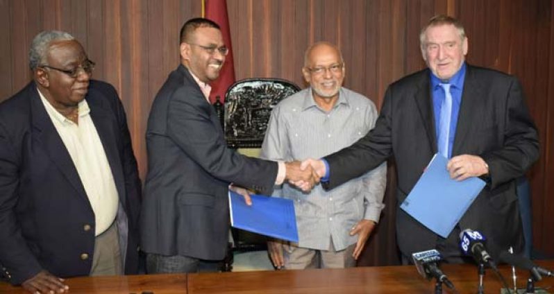 Robert Persaud, second from left, hands over the signed agreement to Mr. Ken Nilsson, (right). At centre is President Donald Ramotar and Mr. Clinton Williams (right) GGMC chairman, is looking on.