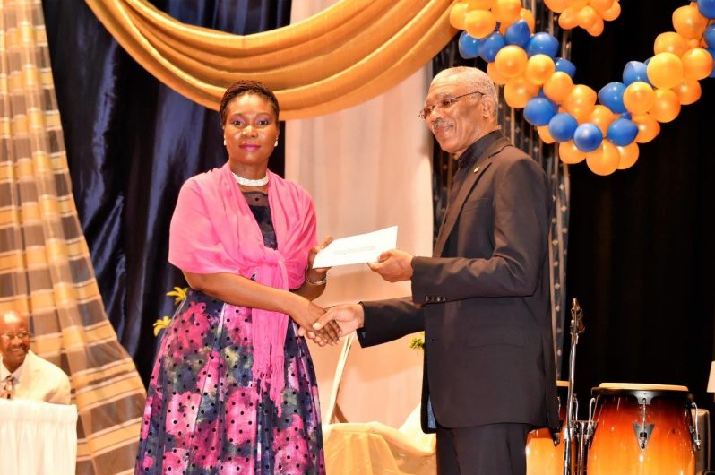 Principal of the CPCE, Ms. Viola Rowe, receiving the $1M cheque from President David Granger, for boosting of Science and technology subjects and facilities at the institution.