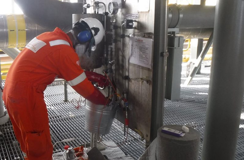 Shivnarine collecting and transferring the first sample of oil for testing