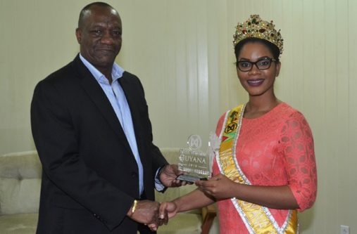 Miss World Guyana 2016 Nuriyyih Gerrard presents a token of appreciation to Minister of State Joseph Harmon