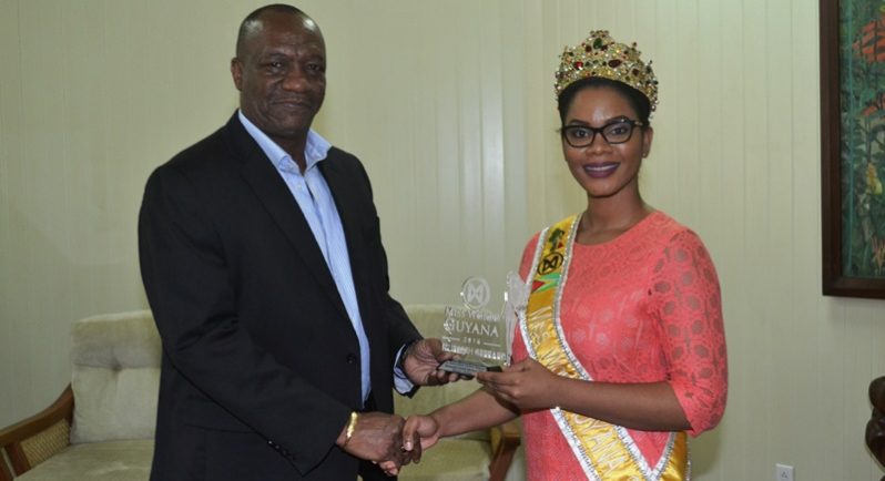 Miss World Guyana 2016 Nuriyyih Gerrard presents a token of appreciation to Minister of State Joseph Harmon