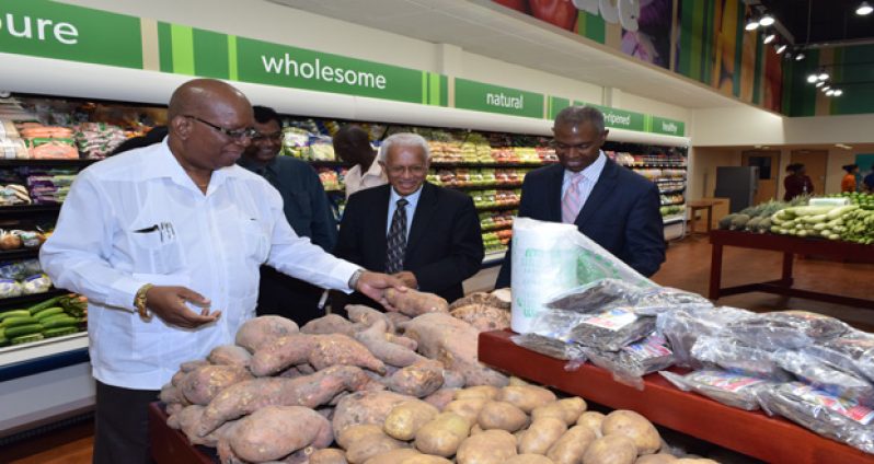 From left: Finance Minsiter Winston Jordan, Vice
President and Minister of Public Security Khemraj Ramjattan,
Massy Country Manager Deo Persaud and Senior Vice President
and Executive Chairman Thomas Pantin, Retail Line of Business
(Massy) yesterday viewing some of the locally grown provisions
on display at the opening of Guyana's largest supermarket at
Providence on the East Bank of Demerara
