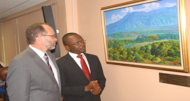 CARICOM Ambassador Irwin LaRocque and Haitian Ambassador Peterson Noel look at a painting of a landscape in Haiti, a gift to CARICOM from President Michel Martelly (Photo by Snnell Nelson)