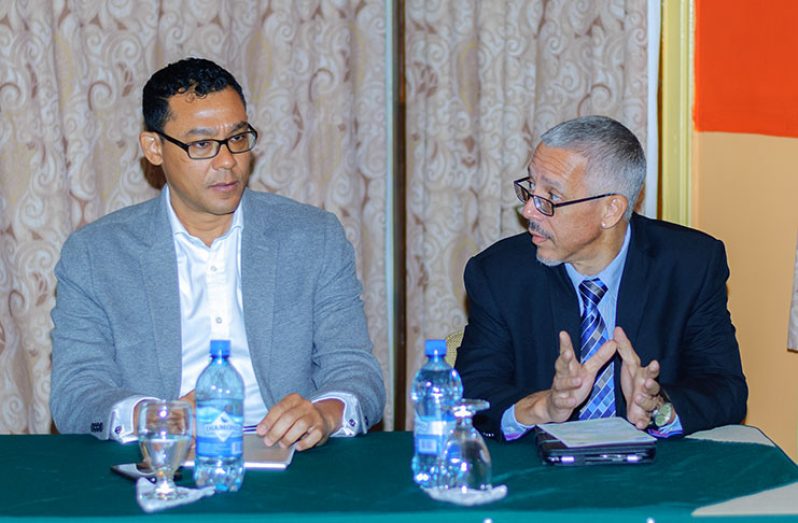 Minister of Business, Dominic Gaskin, and McNair in discussion at the meeting at Grand Coastal International Hotel