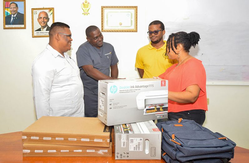 ‘Thank You’. This is what RDC Region Chairman, Brentholl Ashley is saying to REO RDC Four, Pauline Lucas, as he collected some of the equipment, while RDC Region One RHO, Dr Cerdel McWatt and Dr Christopher Seetram of the RHO Department Region Four look on