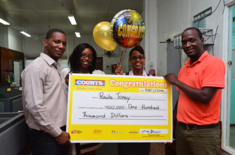 Rawle Toney (right) collects his symbolic cheque from Courts Marketing Manager, Pernell Cummings with the Courts Marketing team looking on