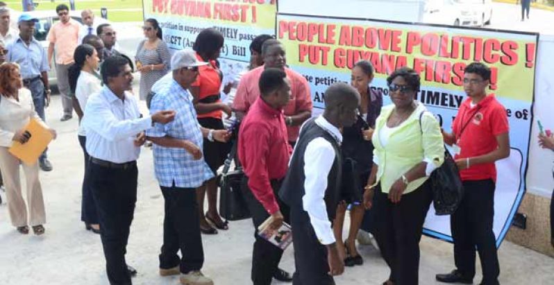 Stakeholders patiently awaiting their turn yesterday at the entrance of the Guyana International Conference Centre to sign a petition for the timely passage of the AMLCFT Bill (Photo by Adrian Narine)