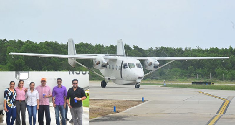 The M28 Skytruck touching  down at Ogle International Airport. Inset is patriarch of the BK Group of Companies, Mr Brian Tiwarie, and his wife (third and fourth right, respectively), and their four children (Photos by Adrian Narine)  
