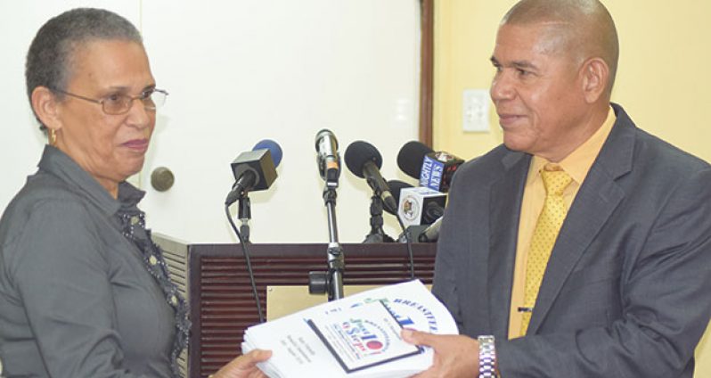 Minister of Public Health, Dr. George Norton receives the Baby Friendly Hospital Initiative (BFHI) report from Lead Consultant Paula Trotter
