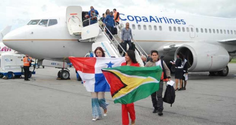 Passengers upon arrival at CJIA during COPA Airlines inaugural flight to Guyana from Panama yesterday displaying the flags of both countries (Cullen Bess Nelson photo)