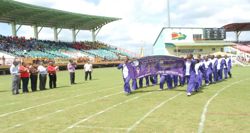 Prime Minister, Samuel Hinds, standing at second right and Minister of Education, Prya Manickchand (third left), takes the salute from Defending Champions, District 11 (North Georgetown), during yesterday’s march past of athletes at the Providence National Stadium. (photo by Sonell Nelson).