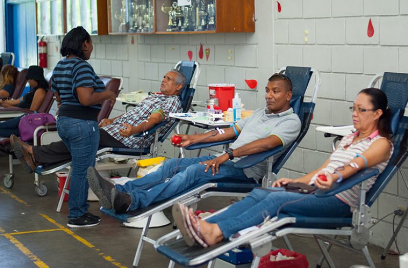 Several persons giving blood at the blood-donation stations yesterday at the Marian Academy.
