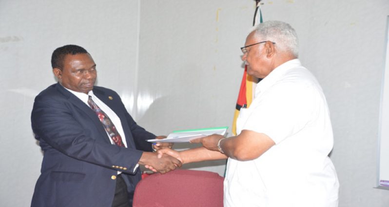 Minister Holder receiving the document from the FAO Country Representative