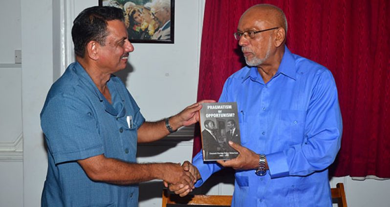 President Donald Ramotar receiving his copy of ‘Pragmatism or Opportunism’ from the author, Mr Hydar Ally at the launching Wednesday