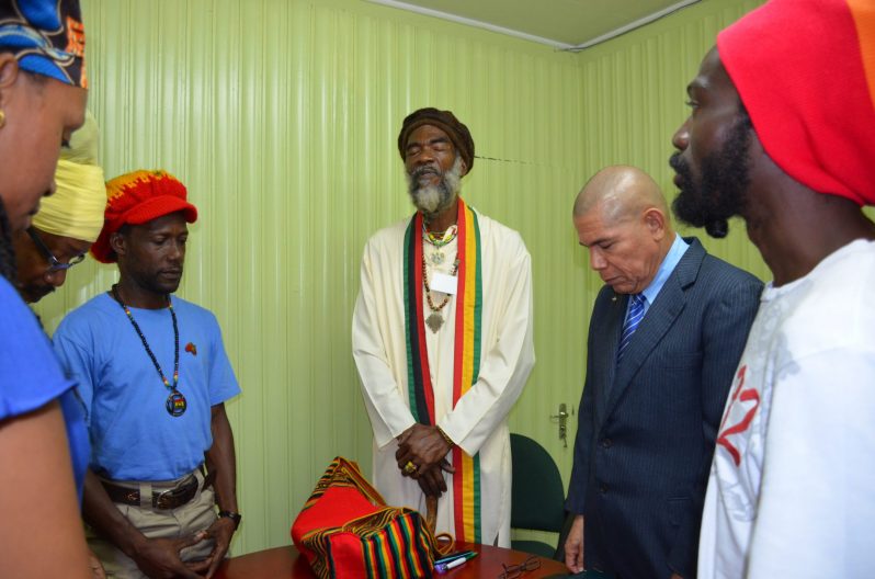 President of the Guyana Rastafarian Association, Ras Simeon, leads the group in prayer before the commencement of the meeting