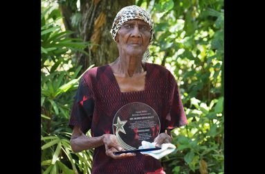 Mildred Agatha Halley displaying her plaque which was presented by the church