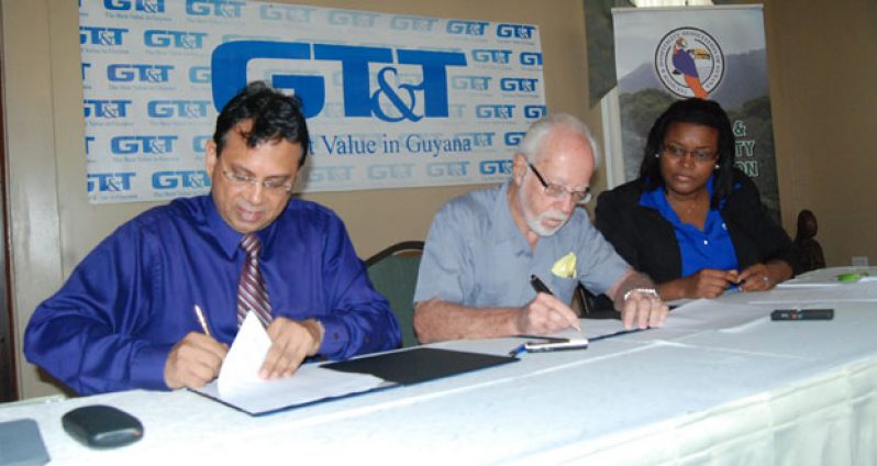 Chief Executive Officer of GT&T, Mr. R.K. Sharma and Head of the THAG, Mr. Kit Nascimento signing the three-year, multi-million-dollar agreement yesterday. Looking on at right is GT&T’s Public Relations Officer Allison Parker (Cullen Bess-Nelson photos)