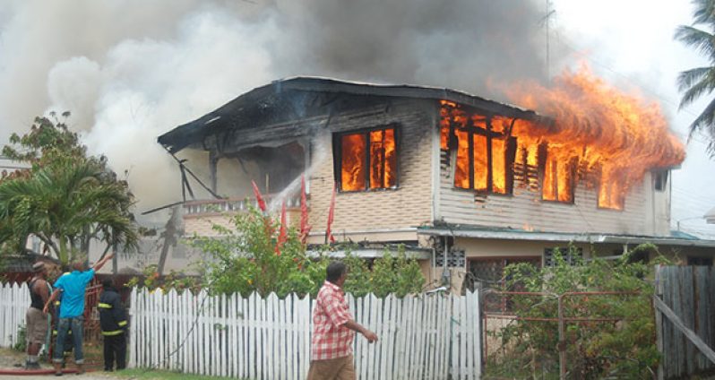 Home-owner, Roy Rupchand watches as his house goes up in flames (Photo by Cullen Bess-Nelson)