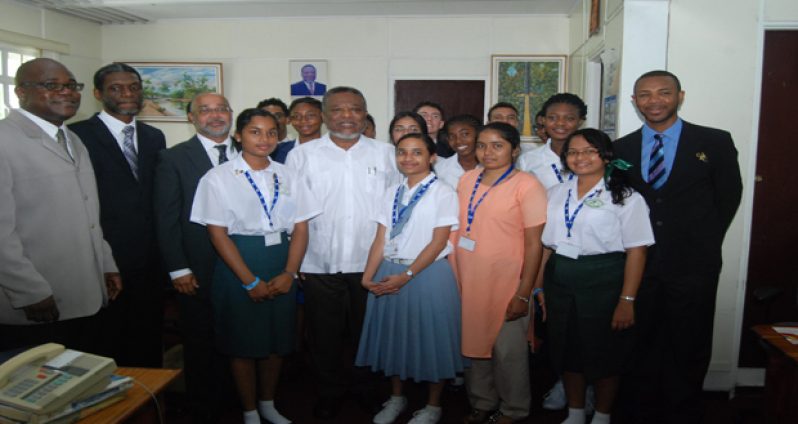 Prime Minister Samuel Hinds with visiting CXC officials and top CSEC students during a courtesy call yesterday