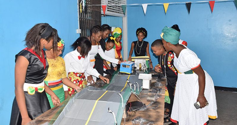 St Joseph High School students are intrigued by a cardboard replica of the Demerara Harbour Bridge