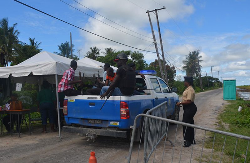 A police vehicle makes it way past a barricade along the roadway leading to the Lusignan Prison on Friday morning.