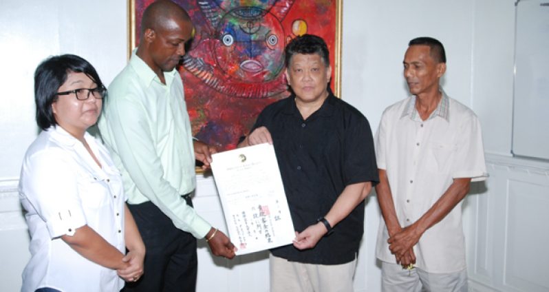 Master Frank Woon-A-Tai (second right) presenting the karate books to Mr Alred King, Permanent Secretary in the Ministry of Culture, Youth and Sport. Witnessing the proceedings are Mr. Jeffery Wong, GKC Vice-Chairman (right), and Ms Vivien Connelly, GKC Treasurer