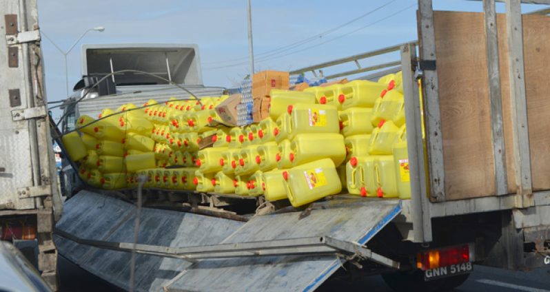 The consignment of oil comes tumbling out as the left rail of the truck gives away.