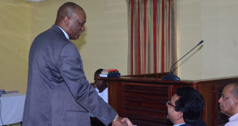 APNU’s Joe Harmon exchanges a handshake with Attorney General Anil Nandlall on arrival at the COI hearings yesterday. In photo, at right, is Home Affairs Minister Clement Rohee.