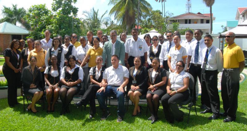 Captain Gerry Gouveia (in suit) is flanked by employees of Roraima Airways on the lawns of Duke Lodge. Seated directly in front of him (centre) are his wife, Captain Debbie Gouveia, and son, Kevin (Photo by Cullen Bess-Nelson)