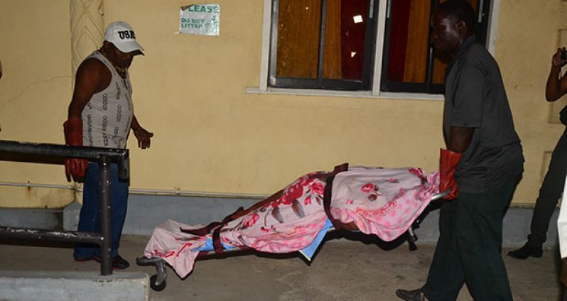 The body of the woman being removed from the hospital by undertakers on Tuesday night.