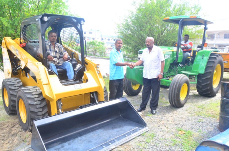 Minister of Local Government and Regional Development, Mr. Norman Whittaker (right) with Eccles/Ramsburg NDC Chairman, Mr. Saed A. Khan along with the acquired machinery