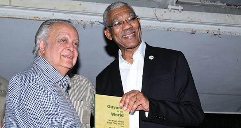 Sir Shridath Ramphal and President David Granger pose with a copy of ‘Guyana in the World’