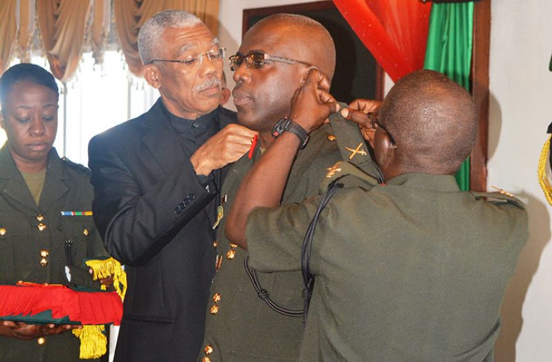 President David Granger and Former Army Chief of Staff, George Lewis decorate Brigadier Patrick West with his new badge of rank