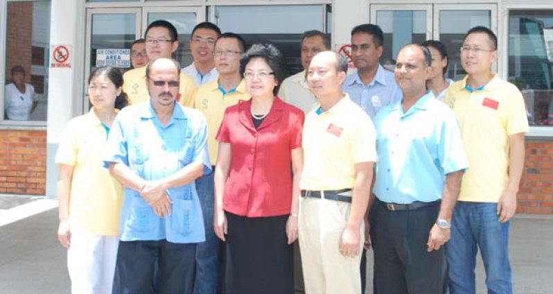 Madam Lin Bin (centre)in front of the GPHC with members of the 11th Chinese Medical Brigade to Guyana (yellow jerseys), Minister of Health Dr. Bheri Ramsaran (Second from left) and other officials of the GPHC yesterday(Cullen Bess-Nelson photo)