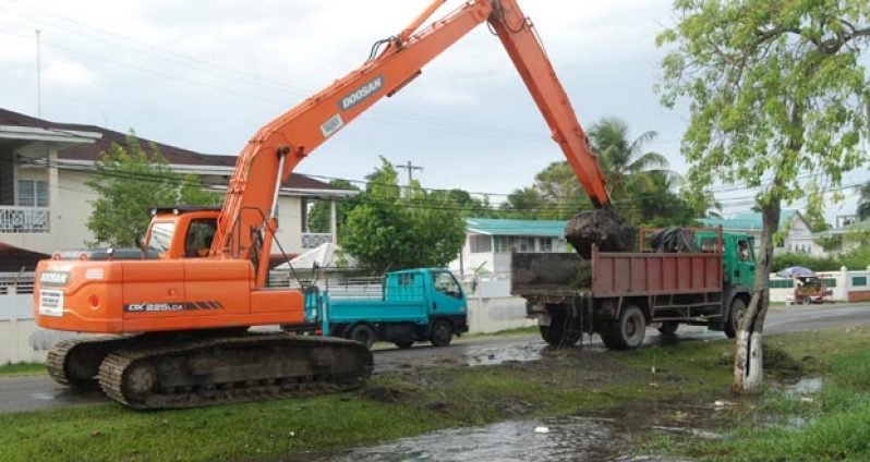 Drainage Works: The excavator at work scooping out debris from the canal between Irving Street and Vlissengen Road (Photo by Sonell Nelson)