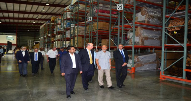 Finance Minister, Dr. Ashni Singh; Vice Chairman & Executive Vice President of Unicomer Group, Guillermo Siman; President of Guyana, Donald Ramotar and Managing Director Unicomer Guyana, Clyde de Hass during the tour of the New Distribution Centre in Eccles. Mexican Ambassador to Guyana Francisco Olguin in the background