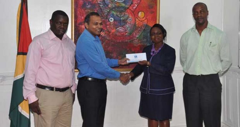 At the handing over ceremony on Wednesday. Receiving the cheque from from Republic Bank’s Ms Jonelle Dummett is Culture Minister, Dr. Frank Anthony. Looking on at left and right are Mr. Andrew Tyndall, Band Manager and Pannist; and Permanent Secretary in the Ministry of Culture, Youth and Sport, Mr. Alfred King respectively