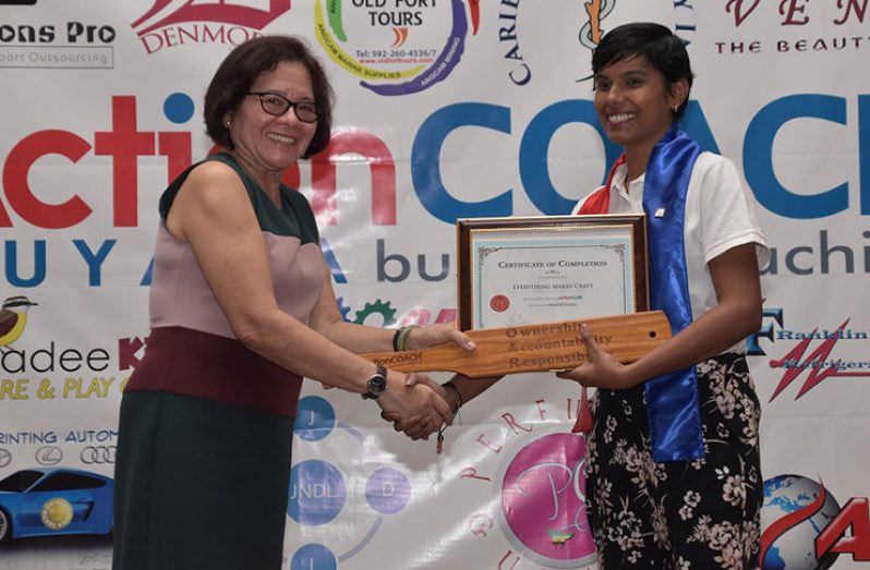 First Lady, Mrs. Sandra Granger hands Ms. Christina DeCambra-Forrester, owner of an up-cycling business, Everything Makes Craft, her certificate of completion of the seven-week Action Club programme.