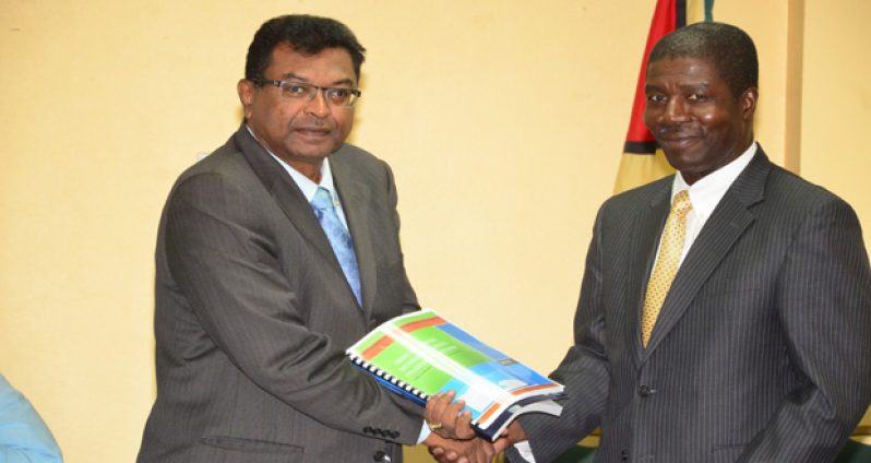 Public Security Minister Khemraj Ramjattan receiving a copy of the report from OAS Representative Jean Ricot Dormeus