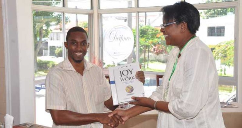 President of the Language Institute, Ms. Cecily Bernard makes extends appreciation with token to photographer at the Guyana Chronicle, Mr. Delano Williams