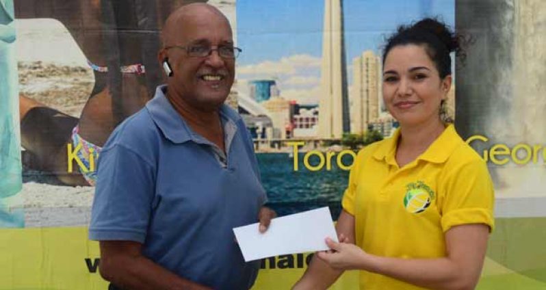 At left, Mr Ron Robinson receives the  ticket from Fly Jamaica’s representative.