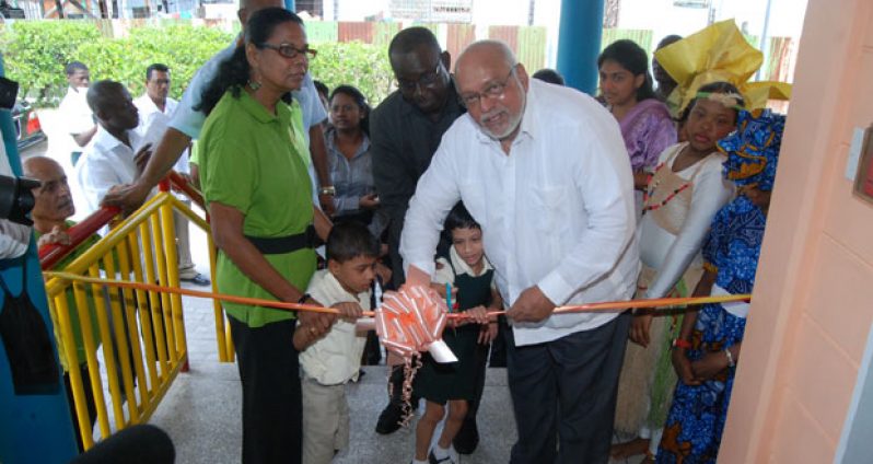 Two children assist President Ramotar to cut the ribbon (Photo by Cullen Bess-Nelson)