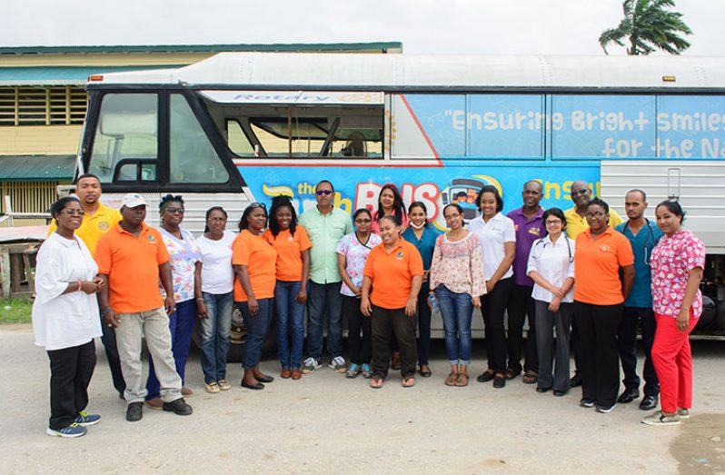 Olive Gopaul poses with the Team of Doctors and other health workers near the Rotary Club Dental Bus (Samuel Maughn photo)