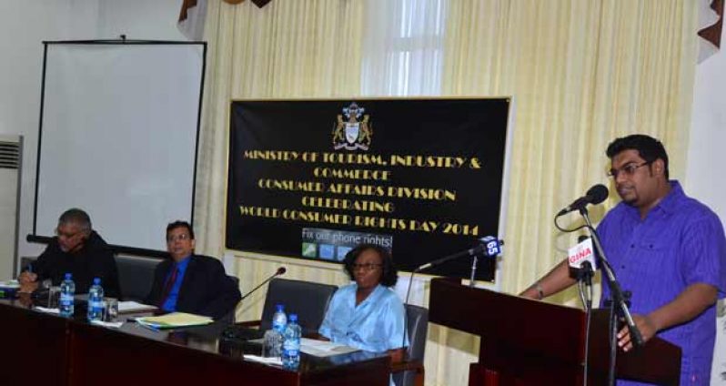 Chairman of the Competition and Consumer Affairs Commission, Ramesh Dookhoo, Chief Executive Officer of GT&T, Radha Krishna Sharma with Chairperson Evadnie Enniss (seated) while Minister of Tourism, Irfaan Ali addresses the gathering yesterday.