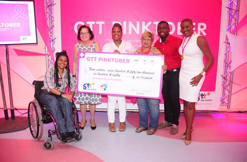 First Lady Sandra Granger (at left), Bibi Hassan (at centre) and GTT’s Marketing Consultant, Samantha Gooden (at right), proudly display the cheque from GTT.  Others are volunteers in the effort (Delano Williams photo)