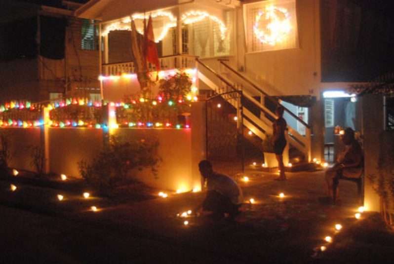 Mr. Chandatt Shivpersad seated outside his gate, deeply gratified at being able to participate in the Diwali lighting up