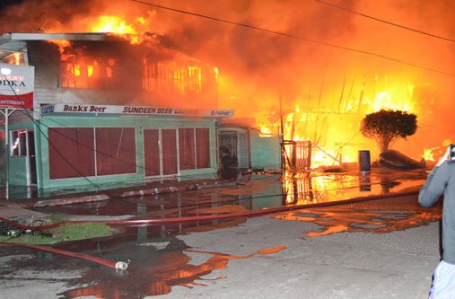 Fire destroys three buildings including a liquor
store Thursday night at Sandy Babb and Railway
Streets, Kitty, Georgetown, leaving over
a dozen homeless. (Stephan Sookram photo)
