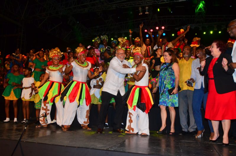 President of Guyana, Donald Ramotar enjoying a ‘festival dance’ surrounded by performing artistes. Also on stage L-R Minister of Foreign Affairs, Carolyn Rodrigues-Birkett; Prime Minister, Samuel Hinds; Minister of Public Service, Jennifer Westford and Adviser on Governance to the President, Gail Teixeira (Adrian Narine photo)